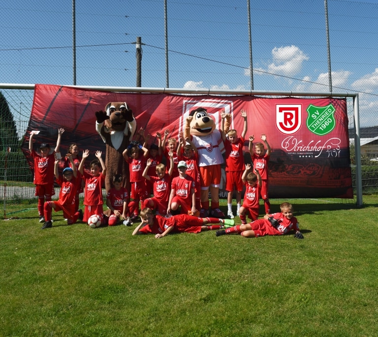 Die Teilnehmer vom Ferien-Fußballcamp 2024 jubeln zusammen mit den Maskottchen Yolybsi und Jahni